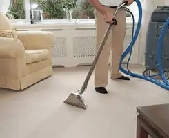 Carpet cleaning professional removing dirt and stains with a hot-water extraction tool in a home, Austin, TX.
