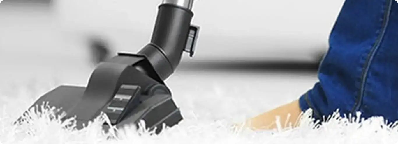 Close-up of a professional vacuuming a white carpet in Round Rock.